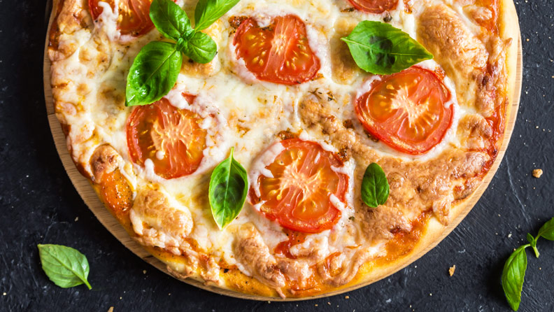personal pizza with mozzarella, fresh tomatoes and basil